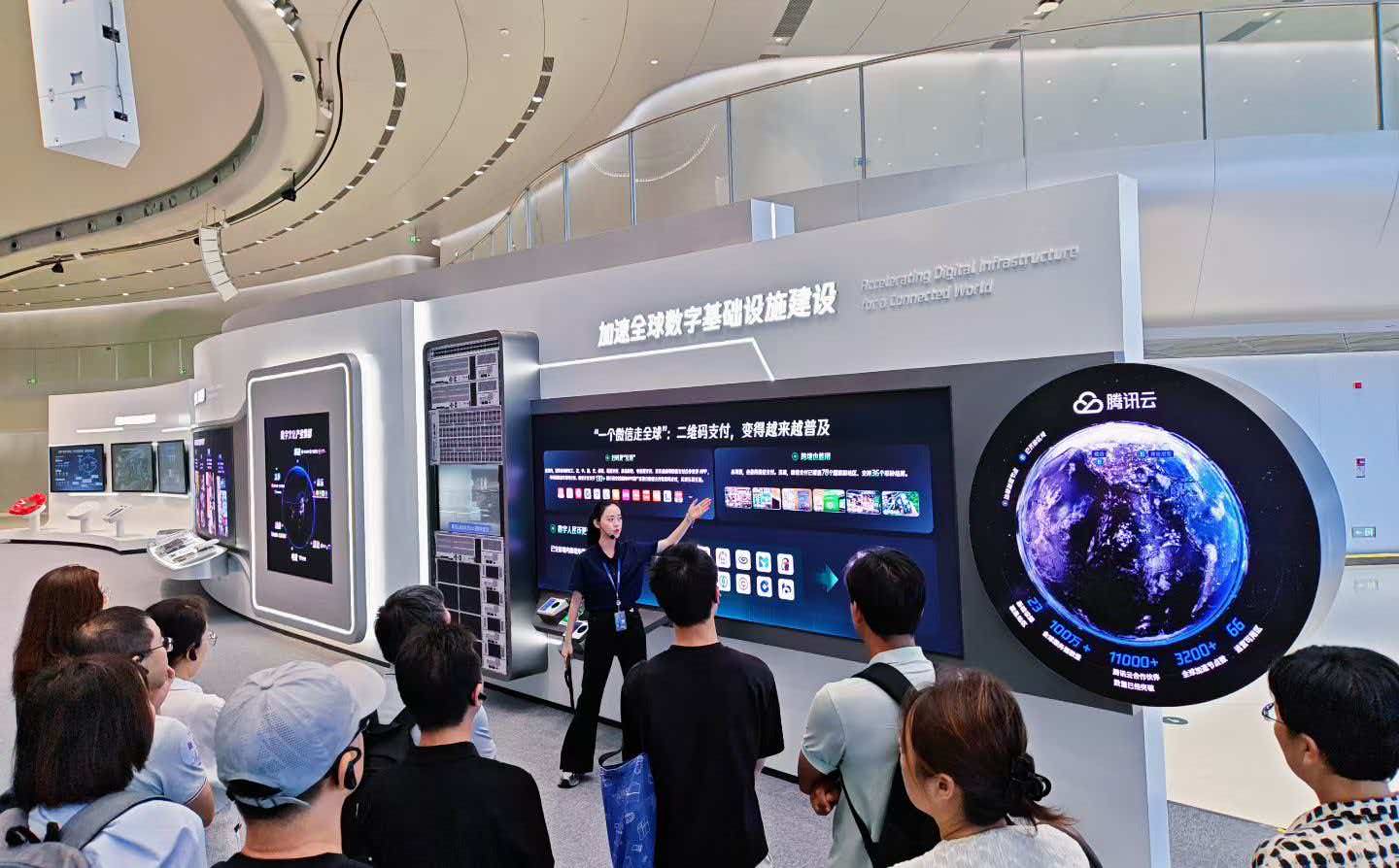 企业家参访团参观腾讯云展厅，讲解员介绍腾讯云加速全球数字基础设施建设