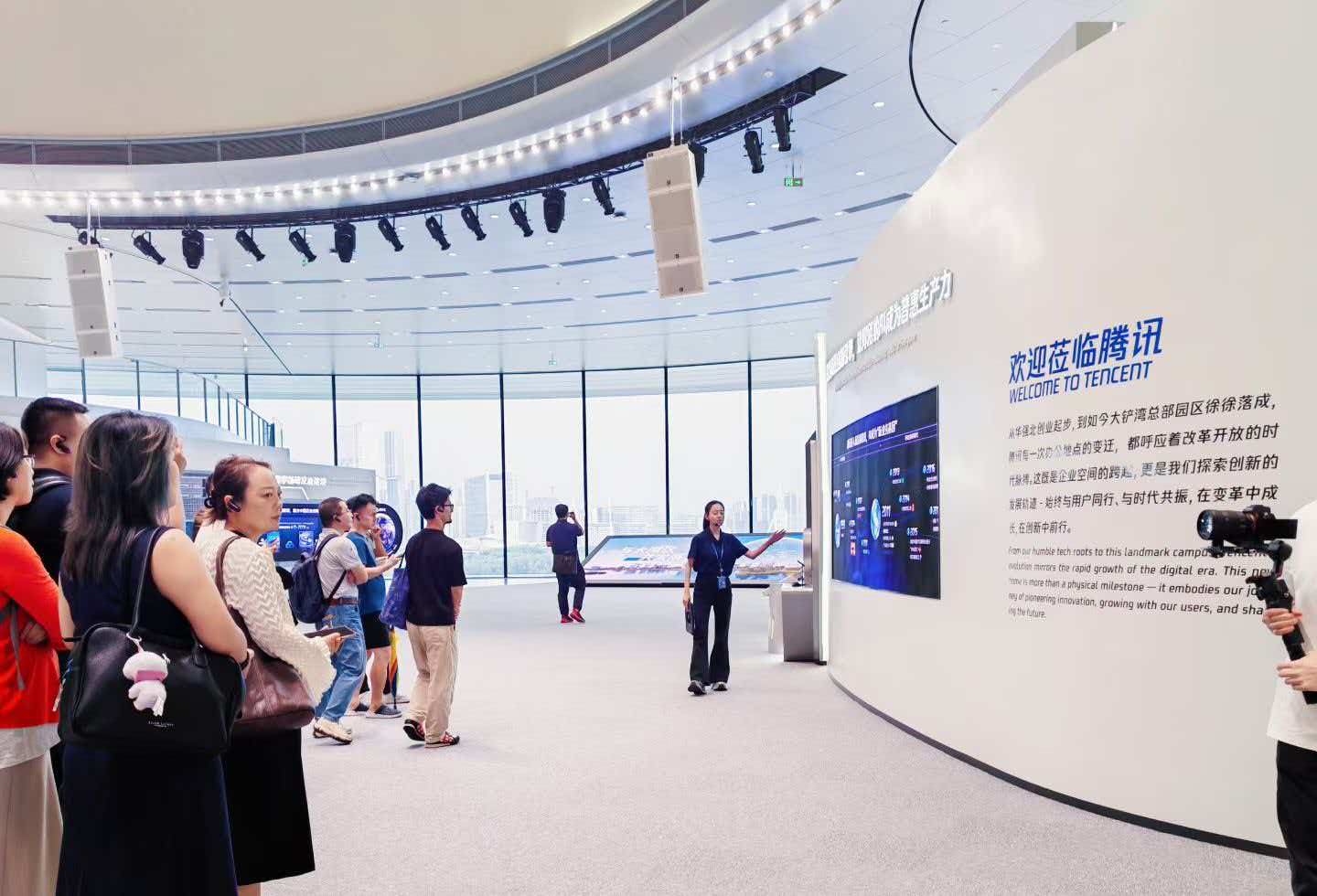 沃瑞斯科技带领企业家参访腾讯展厅，讲解员在欢迎莅临腾讯展墙前讲解